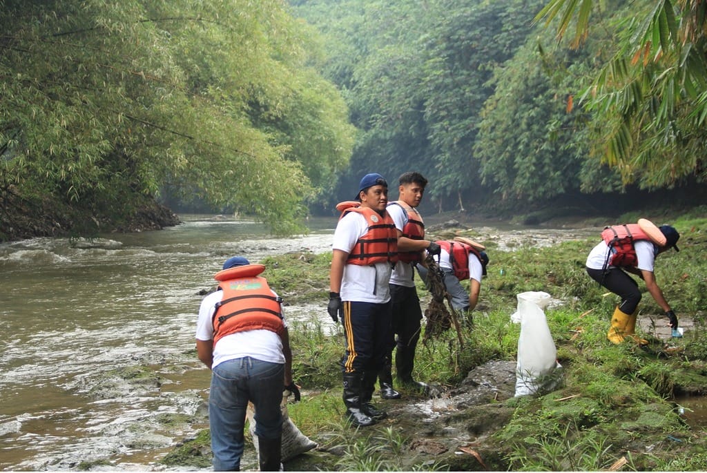 the participants are collecting trash along the banks of the ciliwung river. the trash is then placed into sacks provided by the committee.