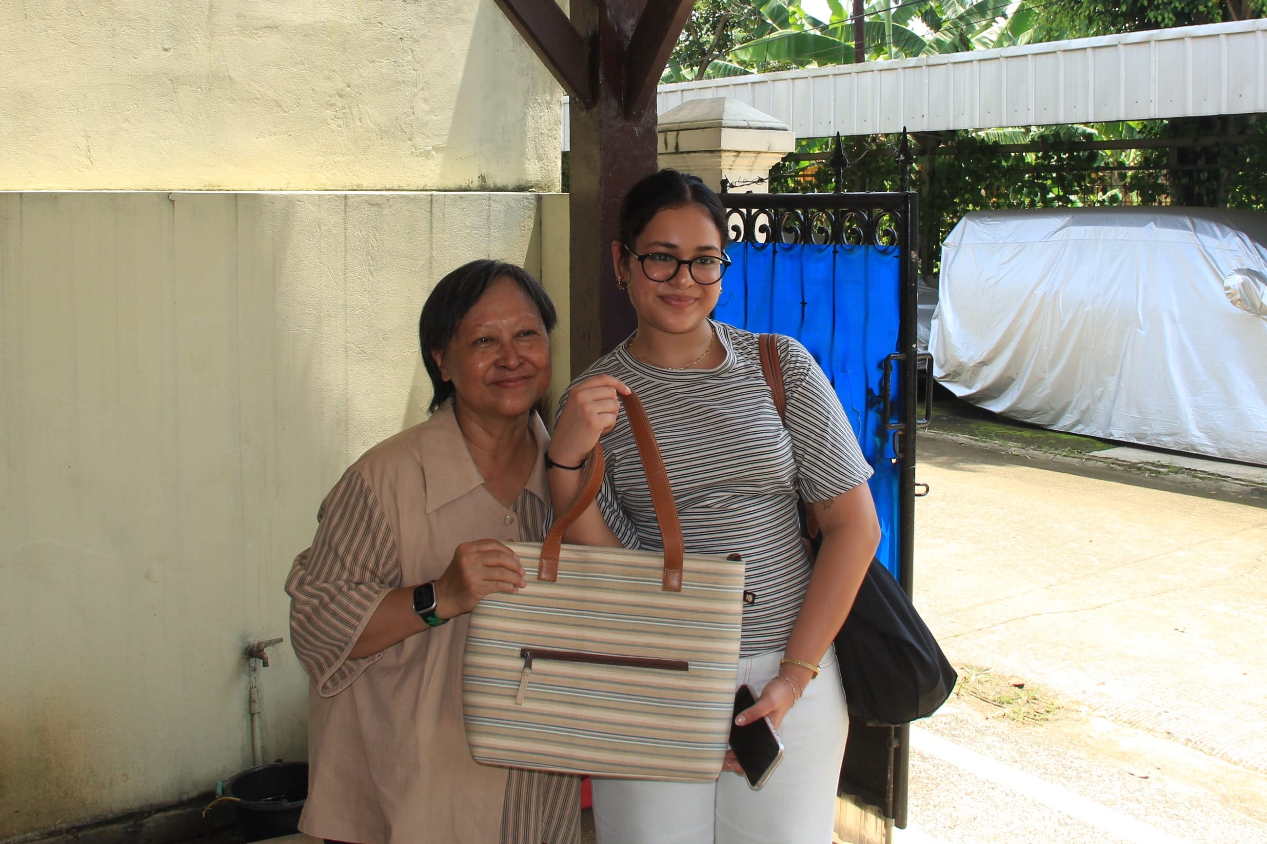 Retno poses for a photo with one of student from the University of Sydney Business School, showing off the XSProjek product she purchased at the workshop.