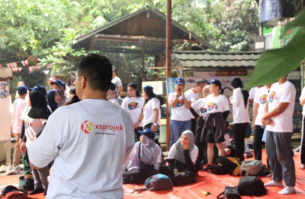 an activity in which xsprojek invited employees of ntt data to care about and participate in cleaning up trash from the ciliwung river.